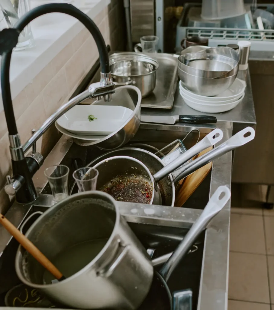 pile of dirty dishes and pots in sink
